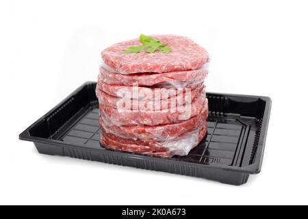 Stapel frisches rohes Rindfleisch Burger Patties in schwarzem Tablett isoliert auf weißem Hintergrund Stockfoto