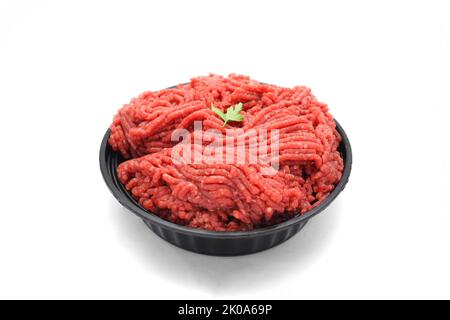 Frisches rohes Hackfleisch in der schwarzen Schüssel isoliert auf weißem Hintergrund Stockfoto