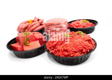 Seitenansicht von verschiedenen rohen Rindfleischschnitten, Hackfleisch, Würstchen und Burger Patties isoliert auf weißem Hintergrund Stockfoto