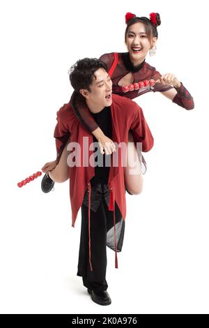 Fröhliches junges chinesisches Paar, das gekandierte Hagebutten isst Stockfoto