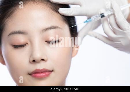 Junge Chinesin, die Botox-Behandlung erhält Stockfoto