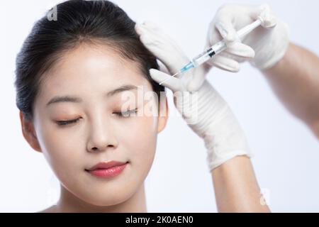 Junge Chinesin, die Botox-Behandlung erhält Stockfoto