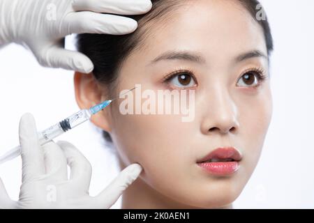 Junge Chinesin, die Botox-Behandlung erhält Stockfoto