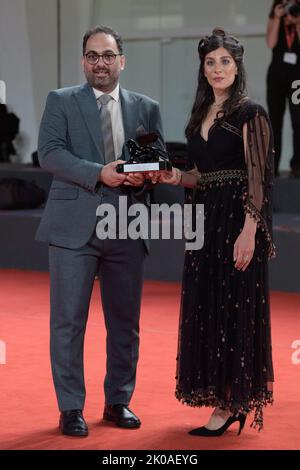 Venedig, Italien. 10. September 2022. Reza Heydari und Mina Kavani posieren mit dem Sonderpreis der Jury für „Khers NIST“ (No Bears), der im Namen des inhaftierten iranischen Regisseurs Jafar Panahi während der Gewinner des Roten Teppichs während des Internationalen Filmfestivals von Venedig (Mostra) 79. am 10. September 2022 in Venedig, Italien, verliehen wurde. Foto von Aurore Marechal/ABACAPRESS.COM Quelle: Abaca Press/Alamy Live News Stockfoto