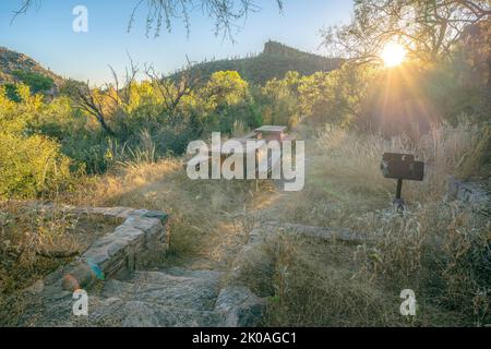 Sonnenuntergang über dem Campingplatz am Sabino Canyon State Park - Tucson, AZ. Campingplatz mit zwei Picknicktischen mit Sitzplätzen und Grillpfosten. Stockfoto