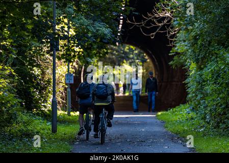 Menschen gehen und Radfahrer fahren Fahrrad durch Tunnel auf Bahnsteig, Edinburgh, Schottland, Großbritannien Stockfoto