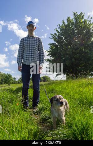 Ein Mann, der einen Grenzterrier in Richmond, Großbritannien, läuft Stockfoto