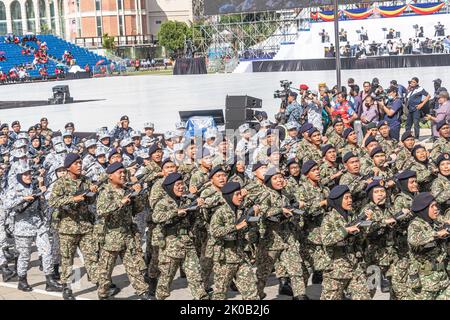 Männer und Frauen der malaysischen Armee und der Royal Malaysian Navy marschieren mit Sturmgewehren während des 65.. Malaysia National Day in Kuala Lumpur. Stockfoto