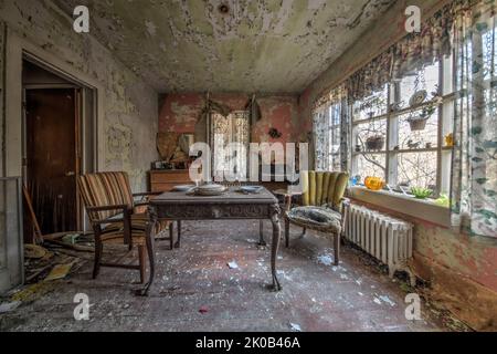 Verlassene Haus mit Bett und Stühlen und Verfall Stockfoto