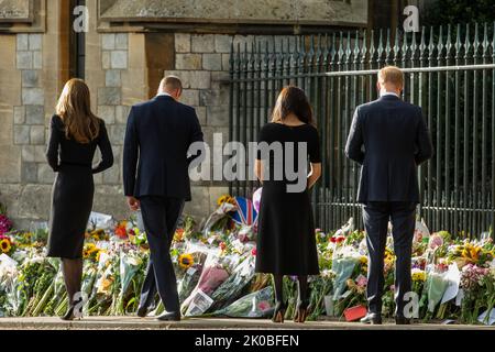Windsor, Großbritannien. 10.. September 2022. Prinz William und Catherine, der neue Prinz und die Prinzessin von Wales, sehen in Begleitung von Prinz Harry und Meghan, dem Herzog und der Herzogin von Sussex, Blumengebete, die nach dem Tod von Königin Elizabeth II. Vor dem Cambridge Gate im Schloss Windsor gelegt wurden Königin Elizabeth II., die dienstälteste Monarchin Großbritanniens, starb am 8.. September 2022 in Balmoral im Alter von 96 Jahren nach einer Regierungszeit von 70 Jahren. Kredit: Mark Kerrison/Alamy Live Nachrichten Stockfoto