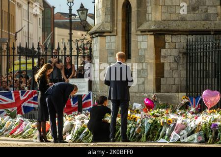 Windsor, Großbritannien. 10.. September 2022. Prinz William und Catherine, der neue Prinz und die Prinzessin von Wales, sehen in Begleitung von Prinz Harry und Meghan, dem Herzog und der Herzogin von Sussex, Blumengebete, die nach dem Tod von Königin Elizabeth II. Vor dem Cambridge Gate im Schloss Windsor gelegt wurden Königin Elizabeth II., die dienstälteste Monarchin Großbritanniens, starb am 8.. September 2022 in Balmoral im Alter von 96 Jahren nach einer Regierungszeit von 70 Jahren. Kredit: Mark Kerrison/Alamy Live Nachrichten Stockfoto