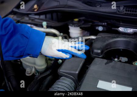 Nahaufnahme Hände des Menschen ist Mechaniker Reparatur Motor des Autos in der Garage, Autoservice, Arbeiter beheben und Einstellen Teil des Automobils mit Problemen in der Stockfoto