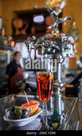 Traditionelle spanische Tapas aus grünen Oliven und ein Sandwich mit Schinken aus Jamon mit einem Cocktail an der Theke einer Bar in Madrid, Spanien Stockfoto