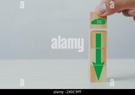 Netto Null und Kohlenstoff Kredit mit Hand halten Holz Würfel Block Symbol CO2 eco und Pfeil auf dem Hintergrund. Stockfoto