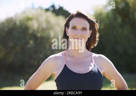 Shes ernst über die Führung eines gesunden Lebensstils. Kopf- und Schulteraufnahme einer attraktiven Frau in Sportkleidung, die im Freien steht. Stockfoto