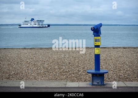 Sprechendes Teleskop mit Blick vom Southsea Beach in Portsmouth, England auf die Isle of Wight mit einer vorbeifahrenden Wightlink Autofähre. Stockfoto