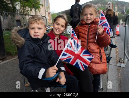 Ballater, Schottland, Großbritannien. 11.. September 2022. 3 Stunden vor dem Vorbeigehen der Cortege kommen junge Menschen in Ballater früh an. Hamish (8) Florence (11) und Gracie (5) kamen von Huntly und haben Sitze in der ersten Reihe. Ballater ist ein Dorf, das dem Balmoral Castle am nächsten liegt und sich heute auf der Route der Cortege befindet, die den Sarg von Königin Elizabeth II. Nach Edinburgh trägt. Iain Masterton/Alamy Live News Stockfoto