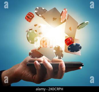 Bild von Casino-Chips, Spielkarten, zwei rote Würfel auf dem Smartphone. Glücksspiel, Casino, Unterhaltung und Gewinnkonzept digital generiertes Bild. Stockfoto
