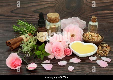 Mystischer Liebestrank und pflanzliche und florale Zutaten für Zauberspruch. Kräuter, Rosenblüten, Honigöl und Rosenquarzkristall. Wiccan und schamanische meine Stockfoto