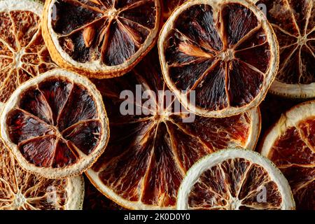 Getrocknete orangefarbene Scheiben Hintergrund. Dehydrierte, knusprige Fruchtscheiben. Haufen sonnengetrockneter knackiger Orangen. Gesunde Mahlzeit Snack. Draufsicht. Stockfoto