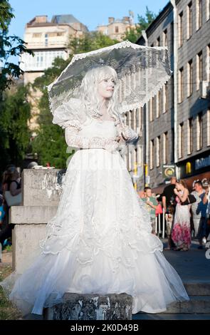 Ein unidentifizierter Pantomime mit Sonnenschirm tritt in der Chreshchatyk Street in Kiew, Ukraine auf. Stockfoto