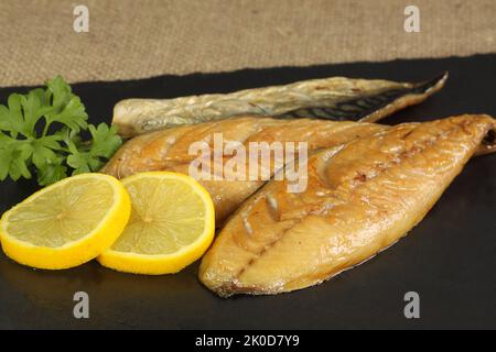 Zwei Filets geräucherter Makrele mit Zitrone und Petersilie Stockfoto