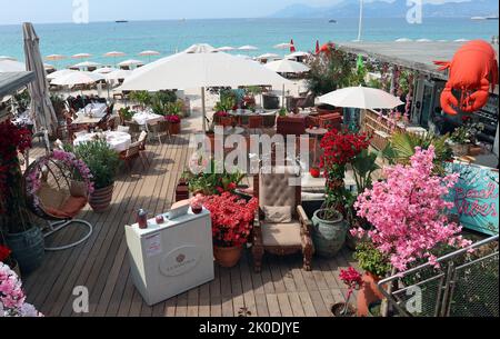 La Mandala Restaurant Boulevard de la Croisette Plage, Cannes: Die Terrasse am Meer mit Blick auf die Lérins-Inseln im Hintergrund Stockfoto