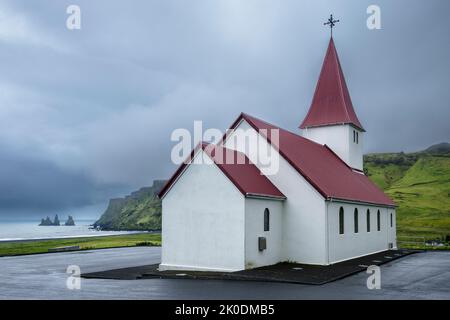 Vik i Myrdal Kirche und Blick auf die Felsformationen von Reynisfjara, Vik, Island Stockfoto