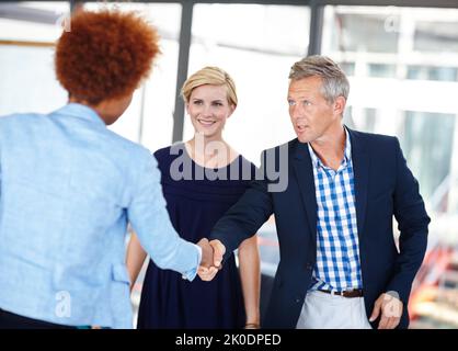 Hinzufügen eines talentierten neuen Mitglieds in sein Team. Ein reifer Business Manager schüttelt einem Mitarbeiter die Hände. Stockfoto