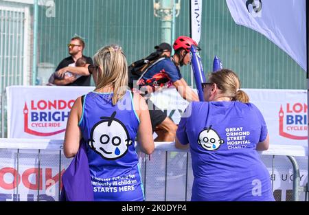 Brighton UK 11. September 2022 - Fahrer, die an der Fahrradtour von London nach Brighton in der Nähe der Ziellinie an der Strandpromenade von Brighton teilnehmen. Die Fahrt wird vielen Wohltätigkeitsorganisationen wie dem Great Ormond Street Hospital childrenÕs Charity : Credit Simon Dack / Alamy Live News Stockfoto