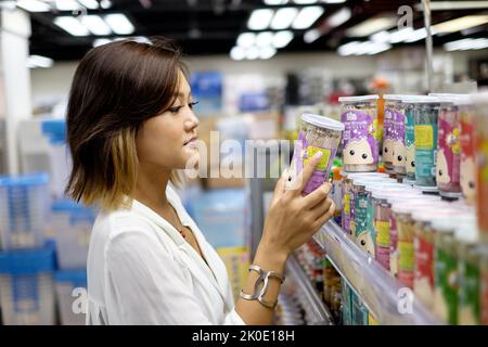 Schöne asiatische Dame, die in einem Kaufhaus einkauft Stockfoto