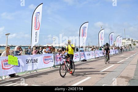 Brighton UK 11. September 2022 - Fahrer, die an der Fahrradtour von London nach Brighton in der Nähe der Ziellinie an der Strandpromenade von Brighton teilnehmen. Die Fahrt wird vielen Wohltätigkeitsorganisationen wie dem Great Ormond Street Hospital childrenÕs Charity : Credit Simon Dack / Alamy Live News Stockfoto