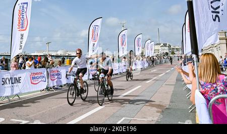 Brighton UK 11. September 2022 - Fahrer, die an der Fahrradtour von London nach Brighton in der Nähe der Ziellinie an der Strandpromenade von Brighton teilnehmen. Die Fahrt wird vielen Wohltätigkeitsorganisationen wie dem Great Ormond Street Hospital childrenÕs Charity : Credit Simon Dack / Alamy Live News Stockfoto