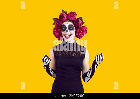 Cheefrul verrückte Frau im Halloween Kostüm mit Kranz aus rosa Blumen und gruseligem Make-up. Stockfoto