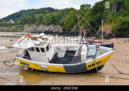 Newquay, Ceredigion, Wales - August 2022: Kleines Fischerboot, das bei Ebbe im Hafen auf Sand ruht Stockfoto