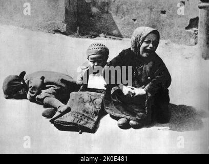 Hungernde jüdische Kinder sitzen verzweifelt auf einer Straße im Warschauer Ghetto, Polen 1941. Das Ghetto war das größte aller Nazi-Ghettos im Zweiten Weltkrieg Sie wurde von den deutschen Behörden im November 1940 eingerichtet. Die Gesamtzahl der Todesopfer unter den Gefangenen des Ghettos umfasste 92.000 Opfer von Hunger und damit verbundenen Krankheiten. Stockfoto