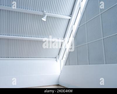 Scheinwerfer, der an der Dachkonstruktion des Hangaufbaus hängt. Moderne Deckenleuchten unter dem stilvollen Gebäude im Dachgeschoss des Gebäudes. Stockfoto