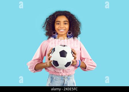 Lächelndes biracial Teenager-Mädchen mit Fußball Stockfoto