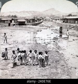 Joseon Era, Korea, 1890-1900. Straßenszene, in der Kinder in der Nähe eines offenen Kanalisationsstroms im Nordwesten von Seoul spielen. Stockfoto