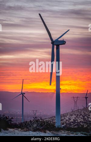 Propeller einer Windturbine warten darauf, dass sich durch einen Canyon Wind bildet, wenn die Sonne aufgeht, um erneuerbare Energie zu erzeugen. Stockfoto