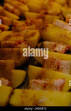 Leckere Bratkartoffeln mit Bacon close up in den Teller auf bereit zum Backen. Stockfoto