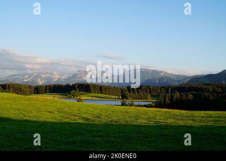 Wanderweg mit Blick auf den malerischen Attlesee in den bayerischen Alpen, Nesselwang, Allgäu oder Allgau, Deutschland Stockfoto