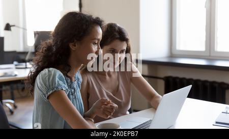 Zwei unterschiedliche Mitarbeiter arbeiten gemeinsam an Projektaufgaben Stockfoto