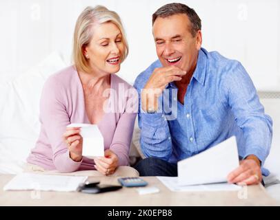 Seniorenpaar berechnet ihre persönlichen Finanzen zu Hause. Porträt eines älteren Ehepaares, das zu Hause seine persönlichen Finanzen berechnet. Stockfoto