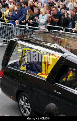 Der Leichenwagen, der den Sarg von Königin Elizabeth II. Trägt, der mit dem Royal Standard of Scotland drapiert ist, führt entlang Canongate in Richtung der Royal Mile, während er seine Reise von Balmoral zum Palace of Holyroodhouse in Edinburgh beendet, wo er einen Tag lang in Ruhe liegen wird. Bilddatum: Sonntag, 11. September 2022. Stockfoto