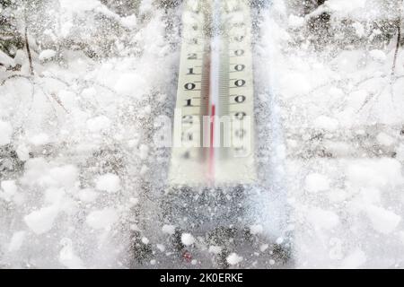 Winterthermometer mit Unschärfe-Effekt. Winterzeit. Thermometer auf Schnee zeigt niedrige Temperaturen in celsius. Frost, zeigt das Thermometer an, dass die Temperatur im heiß ist Stockfoto