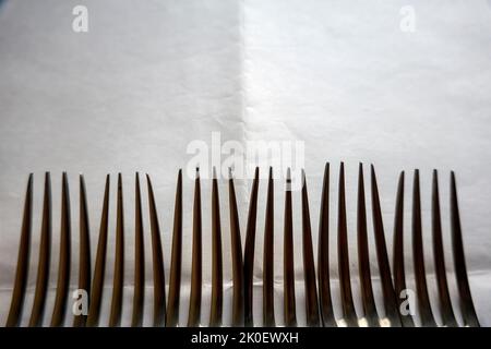 Weißer Hintergrund, auf dem die Spieße verschiedener Gabeln herausstechen Stockfoto