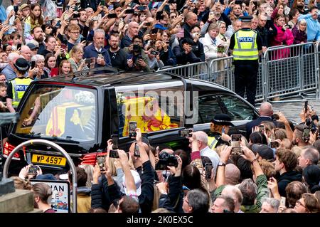 Der Leichenwagen, der den Sarg von Königin Elizabeth II. Trägt, der mit dem Royal Standard of Scotland drapiert ist, passiert die Royal Mile, Edinburgh, auf der Reise von Balmoral zum Palace of Holyroodhouse in Edinburgh, wo er einen Tag lang in Ruhe liegen wird. Bilddatum: Sonntag, 11. September 2022. Stockfoto