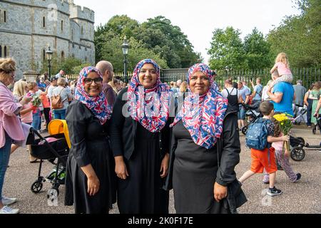 Windsor, Großbritannien. 11.. September 2022. Drei Damen tragen Union Jack-Hijabs, als sie nach dem Tod ihrer Majestät der Königin heute als Zeichen des Respekts kamen, um Blumen zu legen. Quelle: Maureen McLean/Alamy Live News Stockfoto