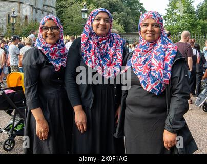 Windsor, Großbritannien. 11.. September 2022. Drei Damen tragen Union Jack-Hijabs, als sie nach dem Tod ihrer Majestät der Königin heute als Zeichen des Respekts kamen, um Blumen zu legen. Quelle: Maureen McLean/Alamy Live News Stockfoto